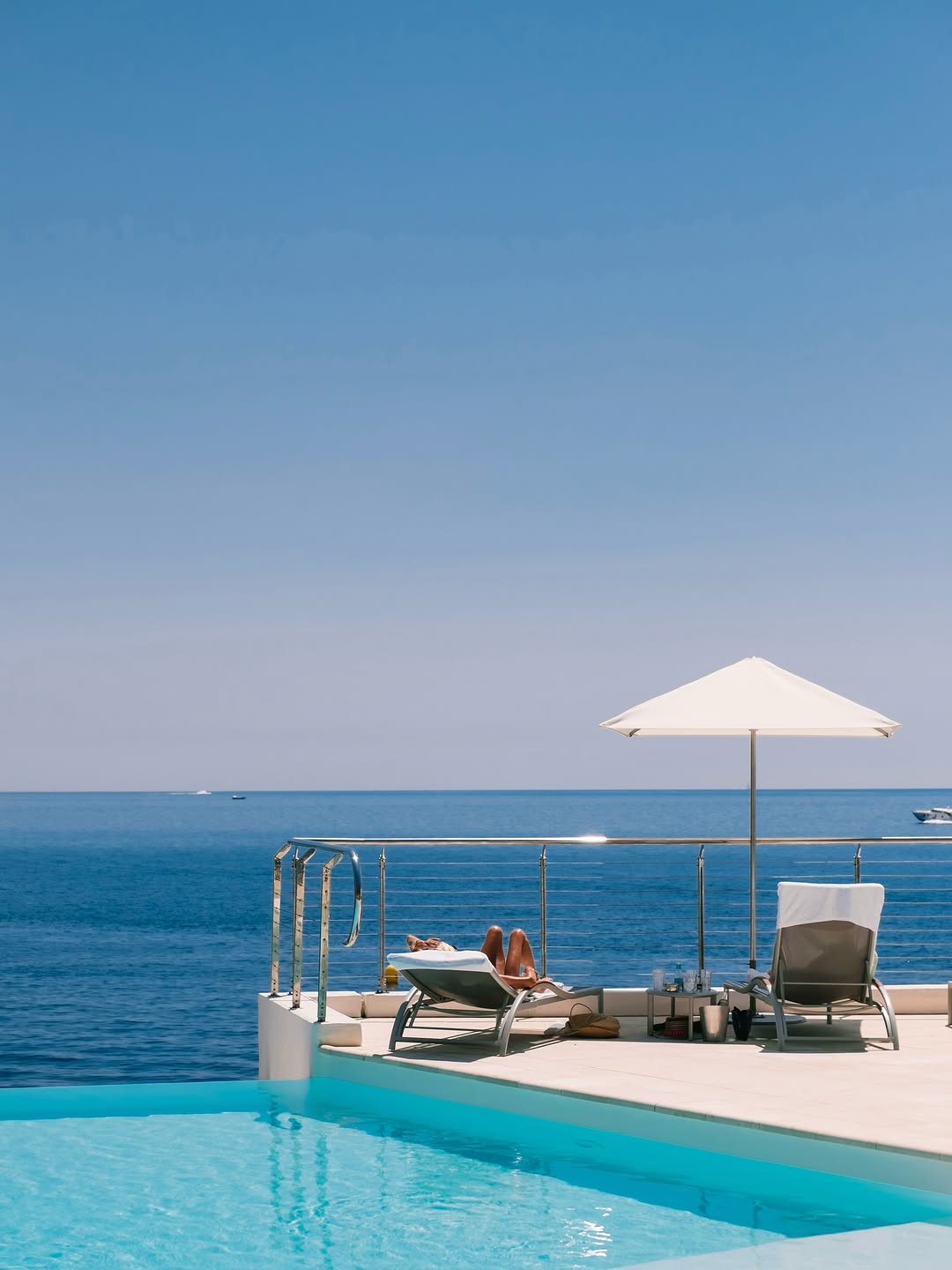 Infinity pool above a still blue sea